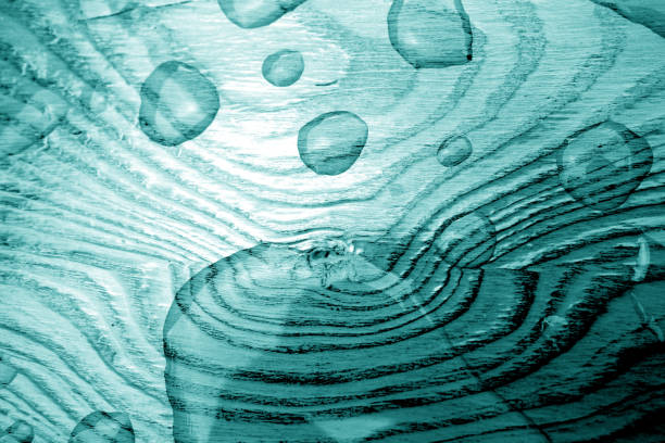 Water drop on wooden surface in cyan tone. Abstract background and texture for design.
