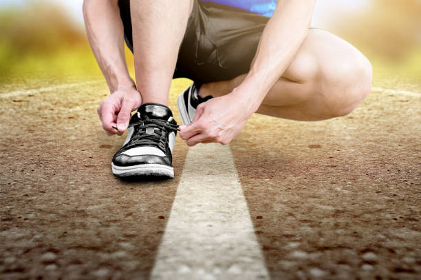 istock Runner man tying running shoelaces on the running track 1195557880