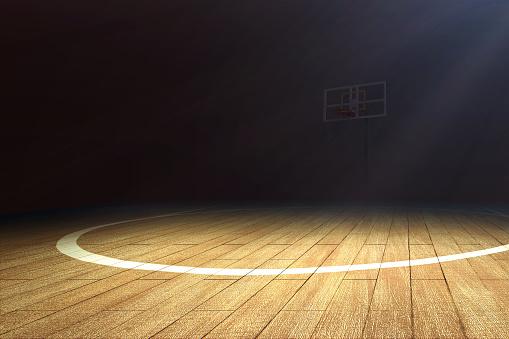 Basketball court with wooden floor and a basketball hoop over dark background
