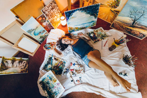 istock Woman painter surrounded with her art 1195560027