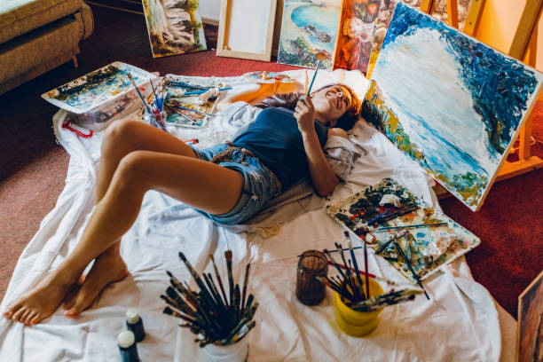 istock Woman painter surrounded with her art 1195560071