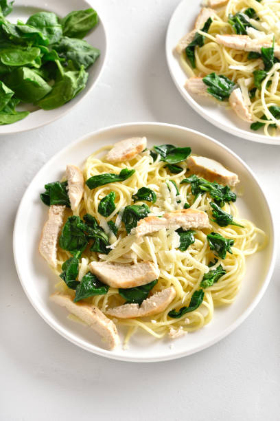 istock Spaghetti with spinach leaves, slices grilled chicken breast and grated cheese 1195561732