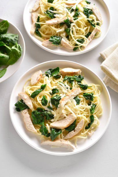 istock Spaghetti with spinach leaves, slices grilled chicken breast and grated cheese 1195561733