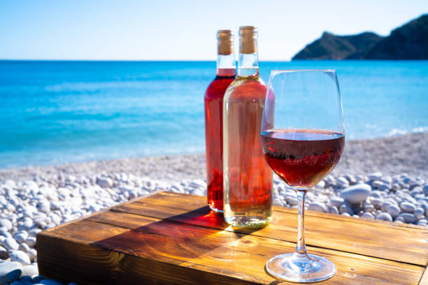 istock Red wine and wine glass on the beach 1195563733