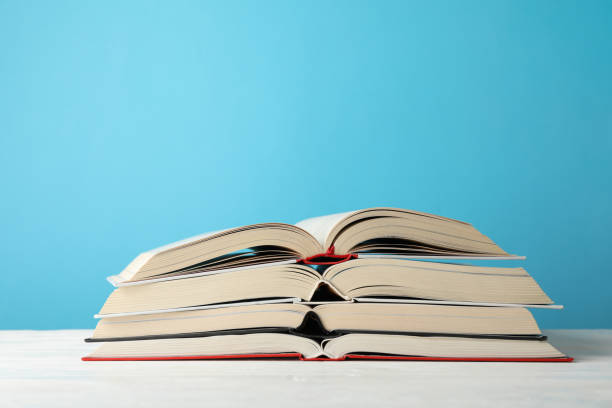 istock Stack of books against blue background, space for text 1195564837