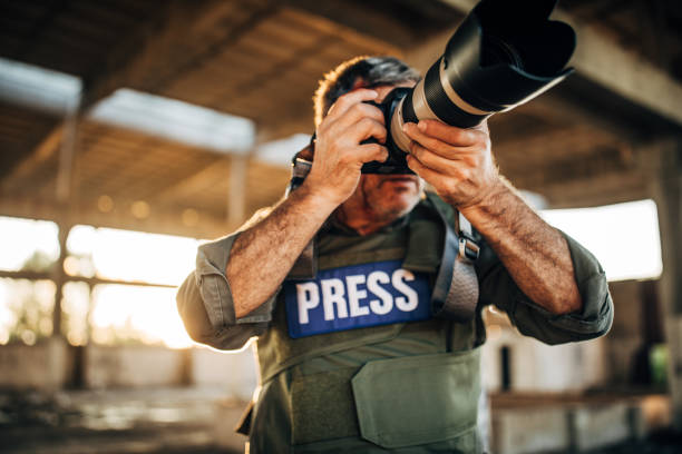 istock War reporter taking photographs with camera 1195566270