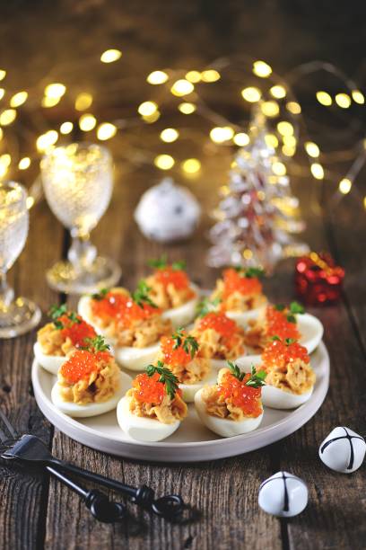 Stuffed eggs with salmon caviar. Christmas background. stock photo
