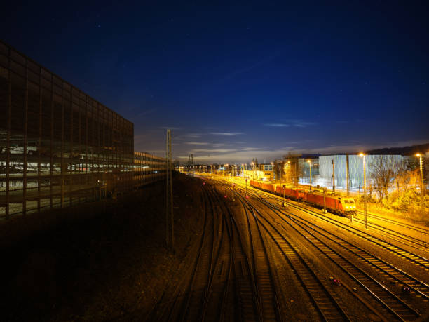istock Railway engines on an illuminated freight yard, with multiple railway tracks, in an industrial area, under a starry sky 1195568523
