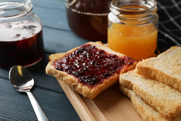 istock Toasts, jam and tea on wooden background, close up 1195568919