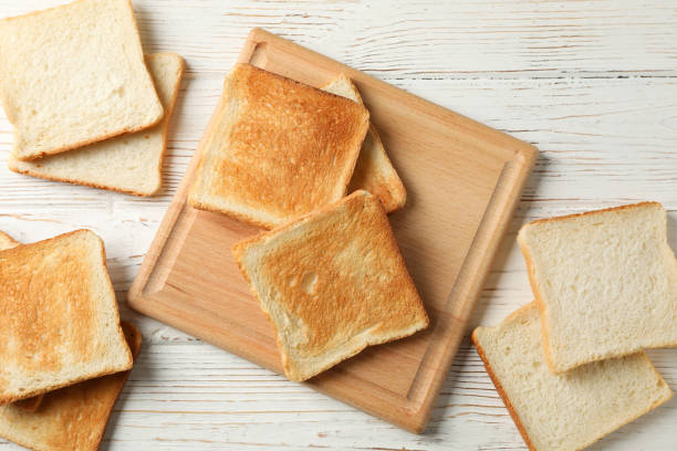 istock Board with toasts on white wooden background, top view 1195568997