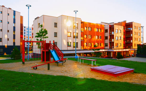 istock Apartment residential house facade architecture with kid playground sun light reflex 1195570209