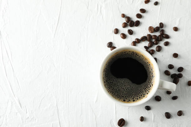 istock Cup of coffee and beans on white background, top view 1195570223