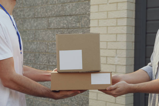 istock Man receiving boxes from delivery man outdoor, blank space 1195570931