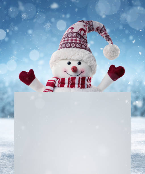 Happy snowman in the winter scenery behind the blank advertising banner with copy space