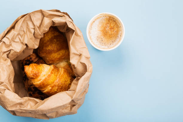 istock Breakfast to go - croissants and coffee with milk on blue background. Top view, copy space 1195572696