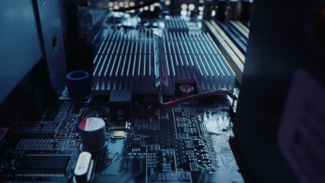 Macro Camera Moving Slowly over Printed Circuit Board, showing Computer Motherboard Components: Microchip, CPU Processor, Transistors. Inside of Electronic Device, Hardware. Neon Colors