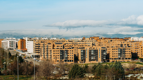 View of residential neighbourhood in Las Tablas, Madrid, Spain with mountain range in background.