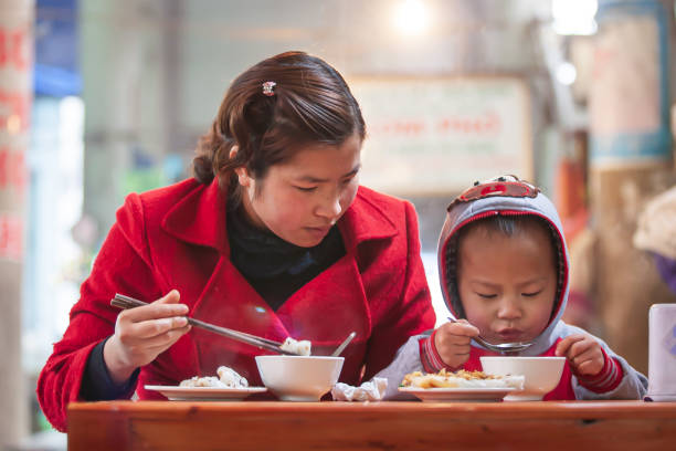 Sa Pa, Vietnam - FEBRUARY 28, 2012: Vietnamese mother and son having breakfast at a local restaurant. Sa Pa.