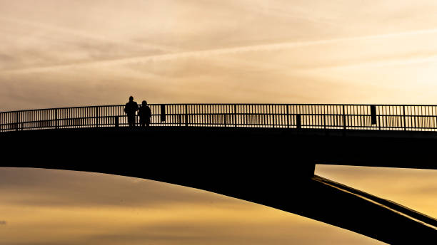 istock People stay on a bridge and look forward in the sunset 1195583505