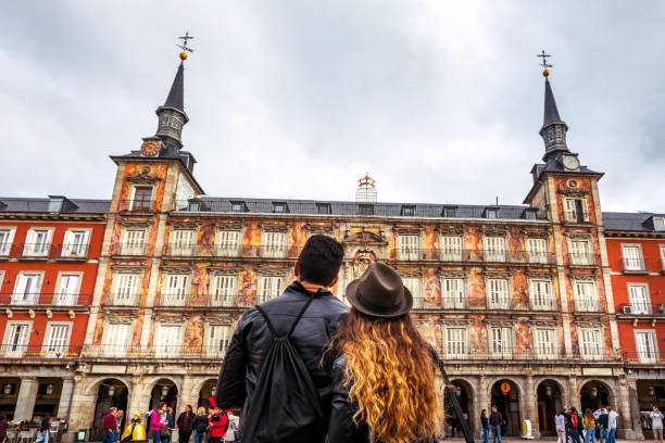 Madrid, Spain - October 19, 2019: Couple of tourists admire Panaderia building in Plaza Mayor in Madrid, Spain.