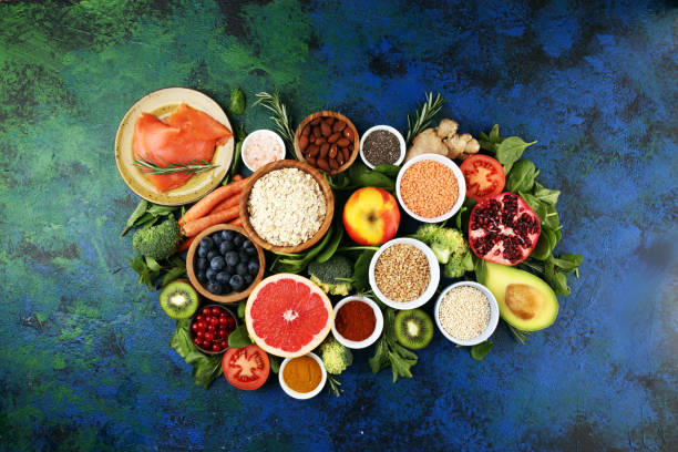 istock Healthy food clean eating selection: fish, fruit, vegetable, cereal, leaf vegetable on rustic background 1195584010