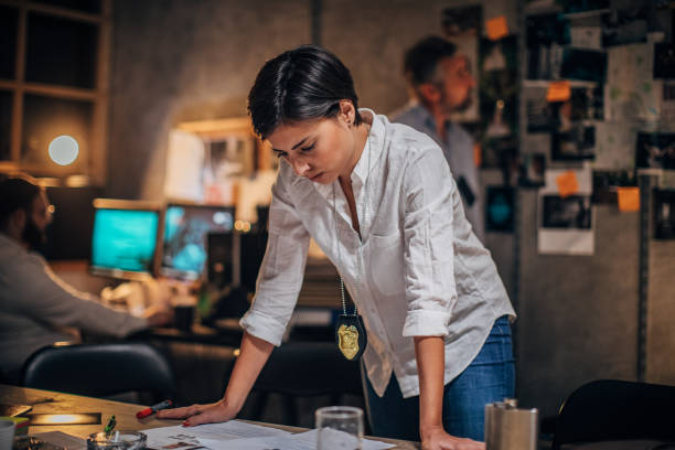 istock Lady detective working late with colleagues 1195584855