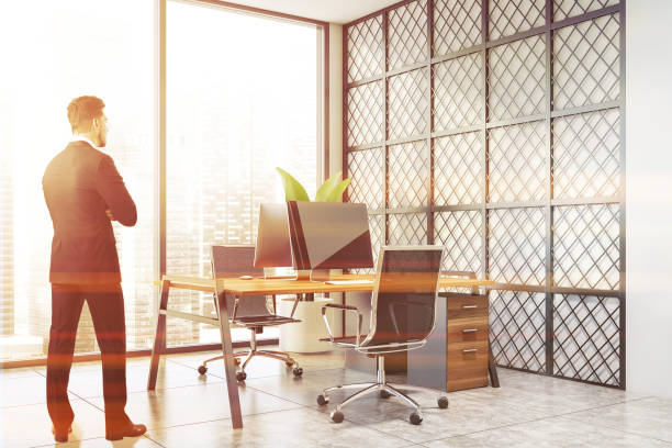 istock Businessman in panoramic white and metal office 1195584936