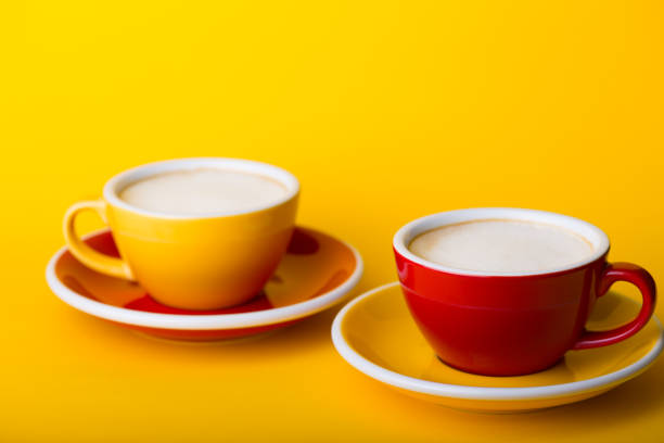 beautiful coffee yellow and red cup with cappuccino on yellow background\