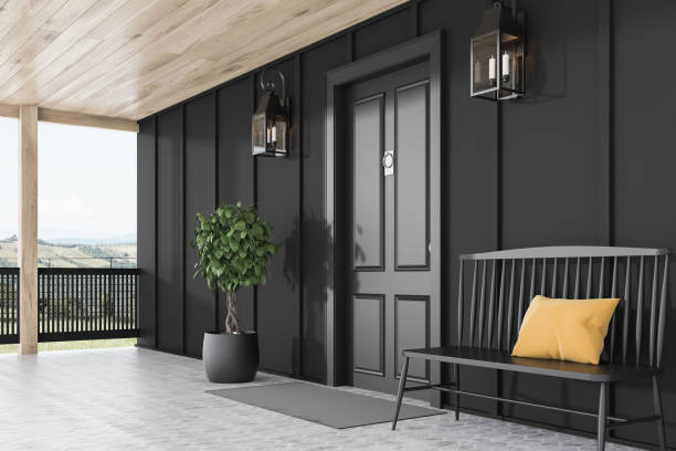 istock Black front door of black house, bench, side view 1195586279