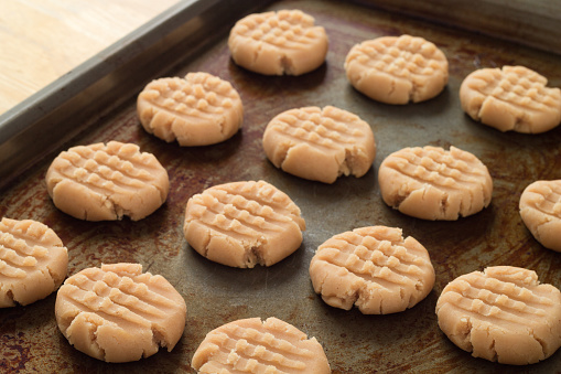 Peanut butter cookies ready for oven on rustic baking sheet