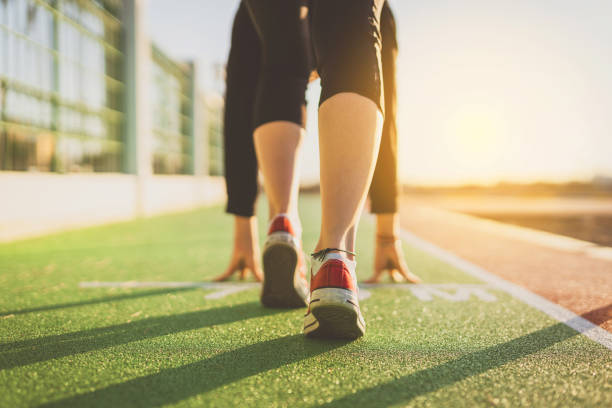 istock Woman in start position on the running track 1195591615