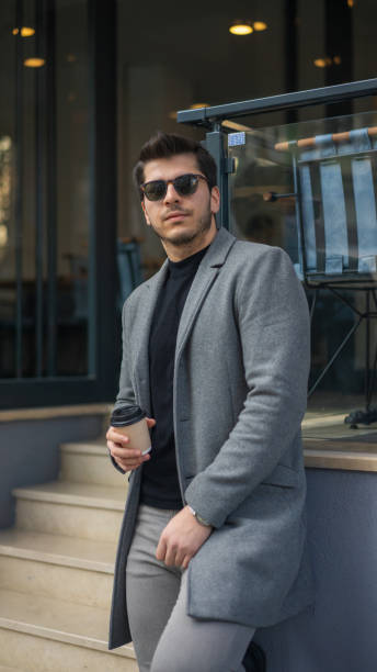 istock Man exiting a cafe carrying coffee to go 1195592628