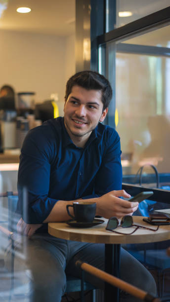 istock Businessman using smart phone and drinking coffee in cafe 1195593148