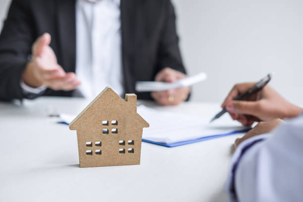 istock Close-Up Of Client Signing Contract While Sitting In Real Estate Agent Office 1195593911