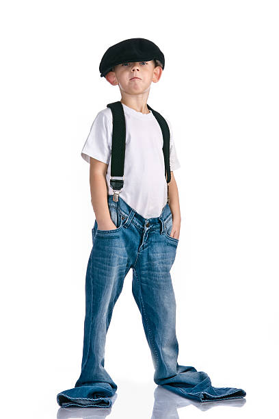 A caucasian redhead  little boy wearing a green baseball cap and a smirk or smile.
