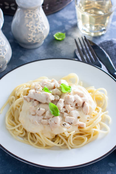 istock Spaghetti with chicken and cheese sauce on a white plate, selective focus 1195595539