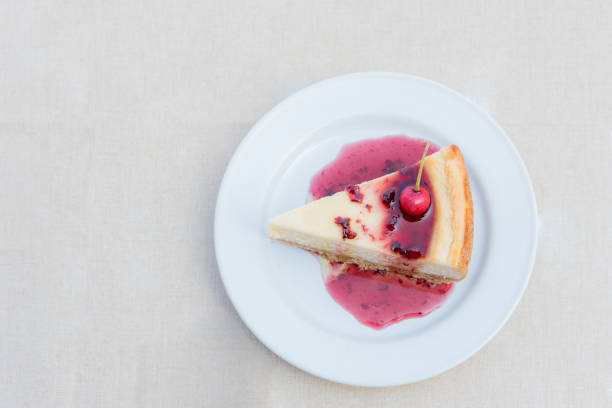 Berry cheesecake slice with Berries Sauce on white plate, tasty dessert stock photo