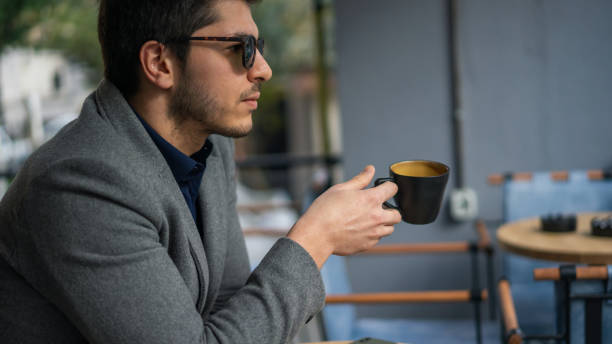 istock Businessman drinking coffee in cafe 1195597743