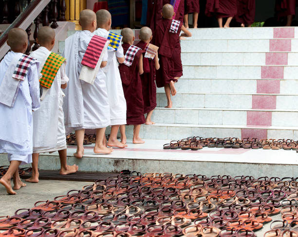 Buddhist monks, Ava, Mandalay, Myanmar. Buddhist monks notable by their religious ceremonial robes can be seen all over Myanmar, especially at their monastery where groups queue and gather for dining or for prayer on Inn Wa or Ava, Myanmar.