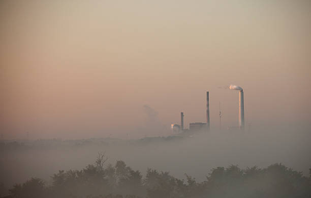 Węgiel aktywowany zespołu silnikowego kominy fabryczne rano Mgła – zdjęcie