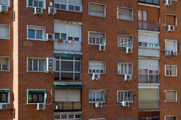 istock Common apartment block building with air ventilation in Madrid, Spain. Architectural structure with air coolers, windows and balconies in the capital city 1195604054
