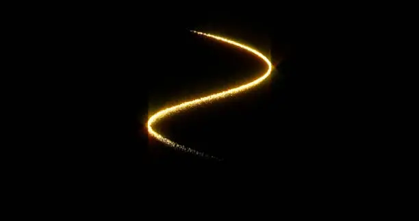 Photo of Gold glitter spiral with glittering light shine sparkles on black background for Christmas holiday. Abstract magic glow of shimmering confetti and firework glittering sparks trail