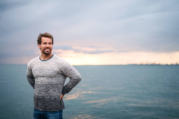 istock Mature man standing outdoors on beach at dusk. Copy space. 1195605005