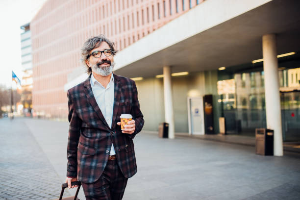 istock Businessman on a journey walking to work and drinking coffee 1195606656