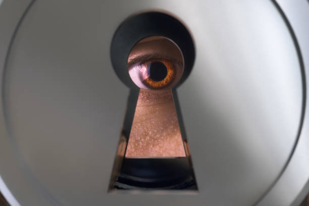 istock The human eye behind the keyhole. 1195613155
