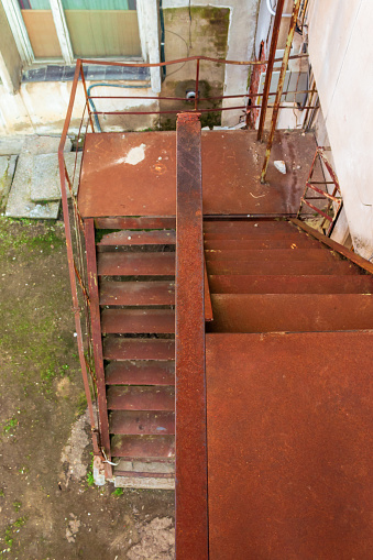 metal stairs. abandoned urban background full of rusty texture. view downside