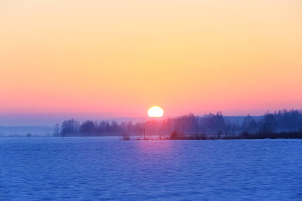 istock Fantastic winter morning. Landscape with fields, mountain, forest and meadow covered with snow. Beautiful sunrise, cloudy sky and orange colorful horizon. Picturesque resort. Rural scenery. 1195615173
