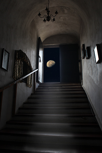 Exit dungeon upstairs overlooking starry sky and moon. Magical view of moon from dark room. Doorway in basement overlooking night sky