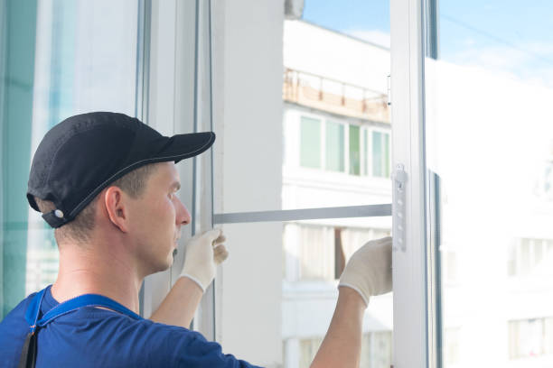 istock a worker in a blue uniform, rear view, removes a mosquito net from a plastic window frame, against the sky 1195616380