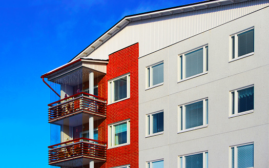 Apartment in residential building exterior. Housing structure at blue modern house of Europe. Rental home in city district on summer. Wall and glass high architecture for business property investment.